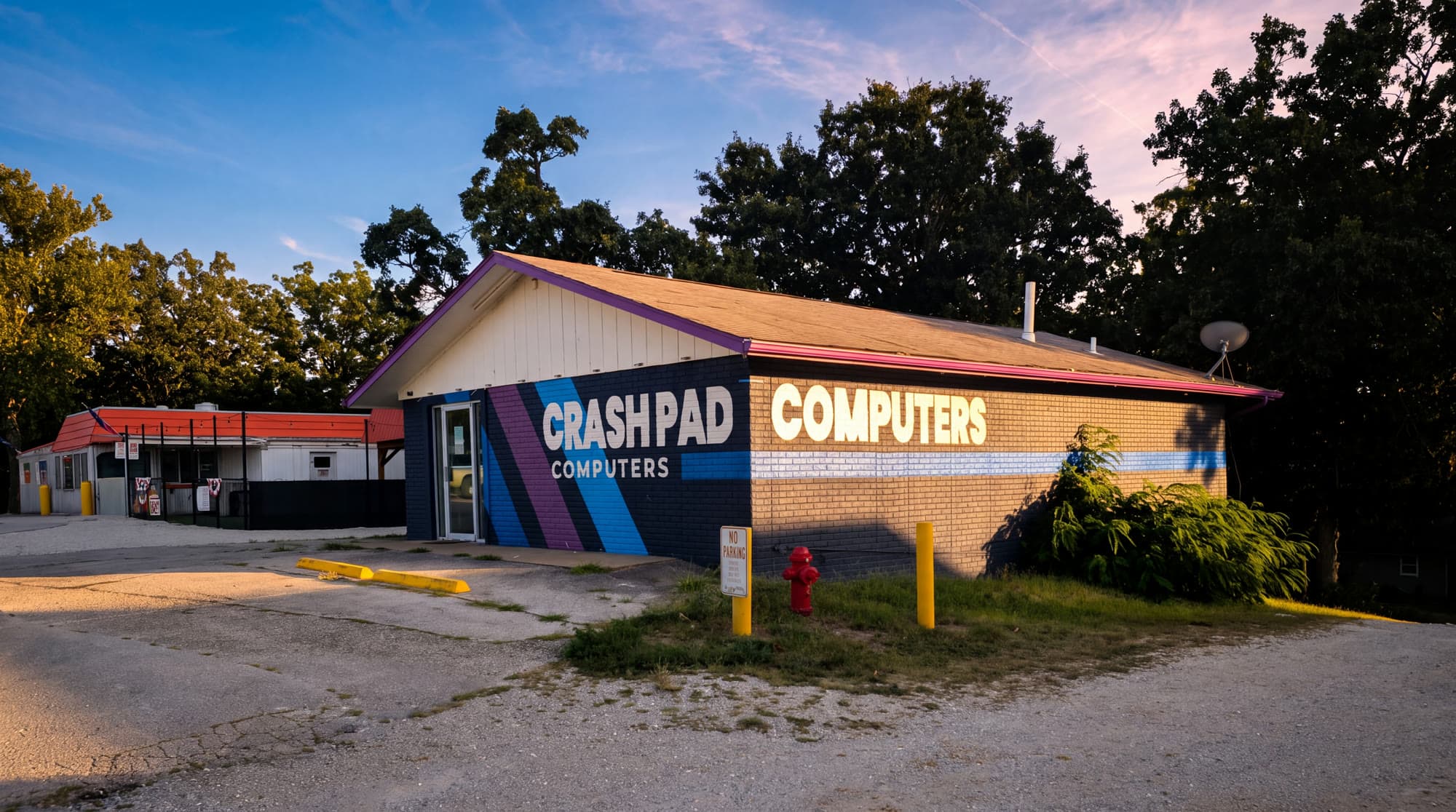 The Crash Pad Computers building on 14327 MO-5 — navy brick with the painted stripe mural — about 20 minutes from Camdenton.